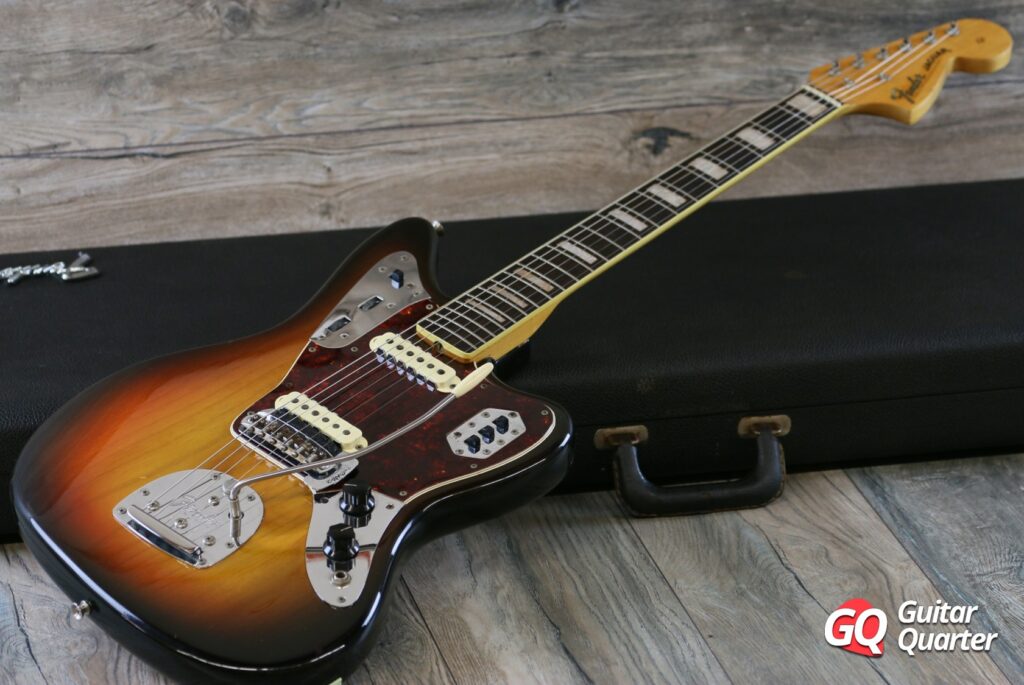 Fender 1967 Jaguar Sunburst de 3 cores com incrustações de blocos retangulares e saia.